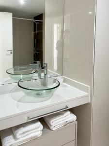 uma casa de banho com um lavatório de vidro e um espelho. em Departamento de un dormitorio - AMARRAS CENTER em Santa Fé