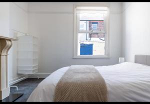 a white bedroom with a bed and a window at Simply Good Night l Penny Lane in Liverpool