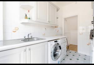 a white kitchen with a washing machine in it at Devondale Road, Penny Lane area in Liverpool