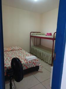 a room with two bunk beds in a room at Hostel Pé na praia - Quartos e Barracas Camping in Caraguatatuba