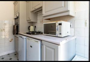 a white kitchen with a microwave on a counter at Simply Good Night l Penny Lane in Liverpool