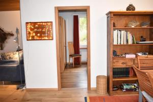 a hallway with a book shelf and a living room at Foil Cotschen (378 Ma) in Valbella