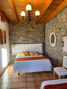 1 dormitorio con cama y pared de piedra en La Pallissa Casa de Turismo Rural, en Moià