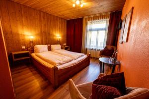 um quarto com uma cama, uma cadeira e uma janela em CURUNA Hotel-Garni em Scuol