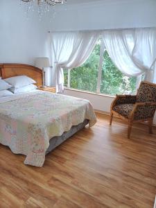 sypialnia z łóżkiem, krzesłem i oknem w obiekcie @336 Bourke w mieście Pretoria
