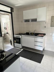 a kitchen with white cabinets and a stove at Allure Morumbi in Sao Paulo