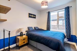 Un dormitorio con una cama azul y una ventana en 3 bed home corporate & contractor House private parking close to city Nottingham city centre, en Nottingham