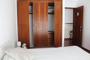 a bedroom with a wooden closet and a bed at Guesthouse Felicidade in Lagos