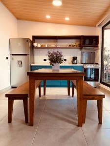 a large kitchen with a wooden table and benches at Casa Macaw in Fortuna