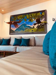 a bedroom with a couch and a painting on the wall at Casa Macaw in Fortuna