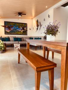 a living room with wooden benches and a couch at Casa Macaw in Fortuna