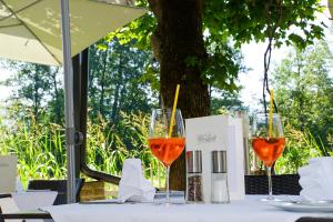 dos copas de vino sentadas en una mesa en Hotel Hudelist, en Krumpendorf am Wörthersee