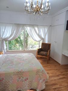 um quarto com uma cama, um candelabro e uma cadeira em @336 Bourke em Pretoria