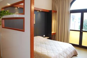 ein Schlafzimmer mit einem Bett und einem großen Fenster in der Unterkunft La Chiocciola Apartments in Santarcangelo di Romagna