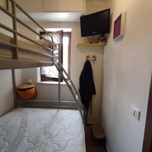 a small room with a bunk bed and a television at casa di Alice, castel del giudice in Isernia