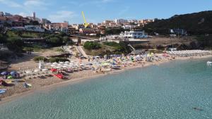 an aerial view of a beach with people and umbrellas at Hotel Corallaro in Santa Teresa Gallura