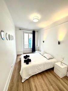 a bedroom with a large white bed with black pillows at Elegant Paris Pantin apartment - line 7 in Pantin