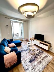 ein Wohnzimmer mit einem blauen Sofa und einem TV in der Unterkunft Elegant Paris Pantin apartment - line 7 in Pantin