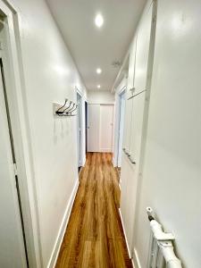 an empty hallway with white walls and wood floors at Elegant Paris Pantin apartment - line 7 in Pantin