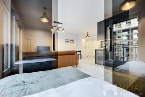 een slaapkamer met een bed en een bureau erin bij Fuzja V by LookAp in Łódź