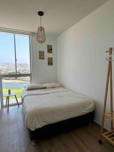 sypialnia z łóżkiem i dużym oknem w obiekcie Departamento de playa con piscina w mieście San Bartolo