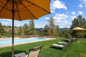 einen Pool mit Stühlen und Sonnenschirmen neben einem Pool in der Unterkunft Tamarron Treasure at Glacier Club #237 in Durango