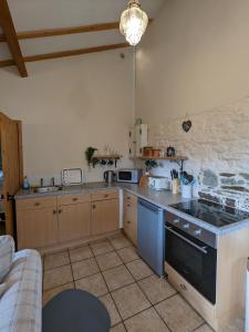 a kitchen with a stove and a counter top at Elegant and secluded 1-Bed Cottage near Bideford in Bideford