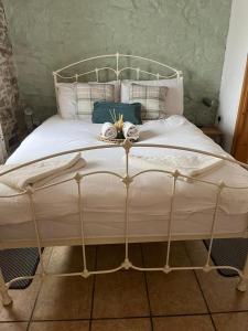 a bedroom with a white bed with a metal frame at Elegant and secluded 1-Bed Cottage near Bideford in Bideford