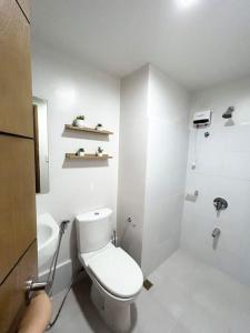 uma casa de banho branca com um WC e um chuveiro em Dreamy Aesthetic Suite in City Center em Cebu