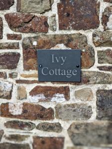 a sign on the side of a stone wall at Elegant and secluded 1-Bed Cottage near Bideford in Bideford