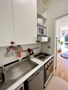 a white kitchen with a stove and a sink at [ Un posto da Sogno ] con parco privato a Vinovo in Vinovo