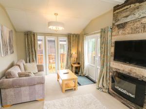 a living room with a fireplace and a tv at Lakeside 12 in Carnforth