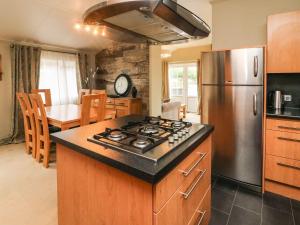 a kitchen with a stove and a stainless steel refrigerator at Lakeside 12 in Carnforth