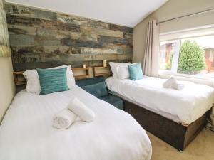 two beds in a room with a window at Lakeside 12 in Carnforth