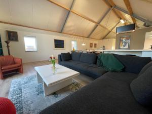 uma sala de estar com um sofá e uma mesa em Unieke loft uitzicht water em Sneek