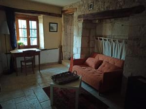 ein Wohnzimmer mit einem roten Sofa und einem Tisch in der Unterkunft Maison de campagne dans Parc National de Forêts in Rochetaillée-sur-Aujon