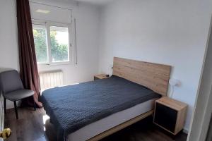 een slaapkamer met een bed, een stoel en een raam bij Bravaholidays-301-Asturias in Blanes
