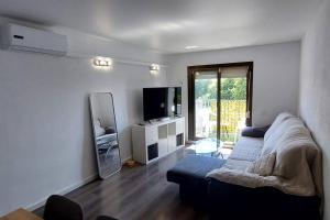 een woonkamer met een bank en een tv bij Bravaholidays-301-Asturias in Blanes
