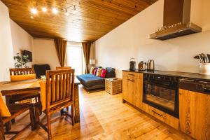 a kitchen with a table and a dining room at Ferienwohnung 1 2 3 (Curuna) in Scuol