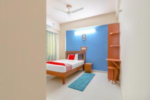 a bedroom with a bed and a blue wall at 79522 The Host in Bangalore