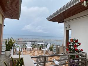 balcón con mesa, sillas y vistas al océano en Kellocks' Seaview Apartelle en Dalaguete