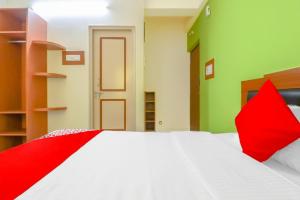 a red and white bed in a room with green walls at 79522 The Host in Bangalore