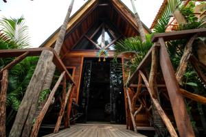 a wooden house with a wooden bridge leading to the door at Villa Éden in Alter do Chao
