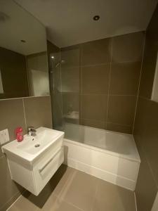 W łazience znajduje się umywalka i wanna. w obiekcie 2 BR Flat in Sutton London NH70 w mieście Sutton