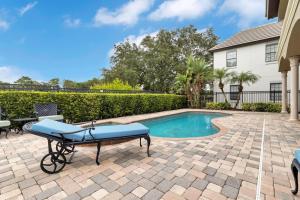 a swimming pool with a bench next to a house at Luxury 5 bed 5.5 bath Villa close to everything in Kissimmee