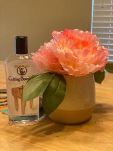 a flower in a vase next to a bottle of alcohol at Cheerful 3 Bdrm space, 2 bath!. You gotta love it! in Oklahoma City