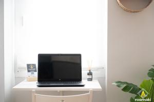 laptopa siedzącego na białym biurku w obiekcie roomaki -tasteful studio in the center w/ parking w Chalkidzie