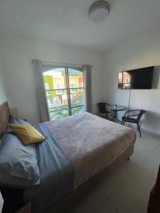 a bedroom with a bed and a table and a window at Casa Spa Palmeras - Habitación Privada in Cancún