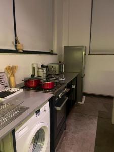 a kitchen with a stove and a washing machine at Marble Nights 2 in Johannesburg