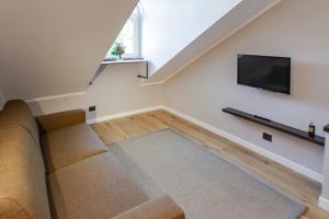 a living room with a couch and a flat screen tv at Vittorio 73 Luxury Apartment in Turin
